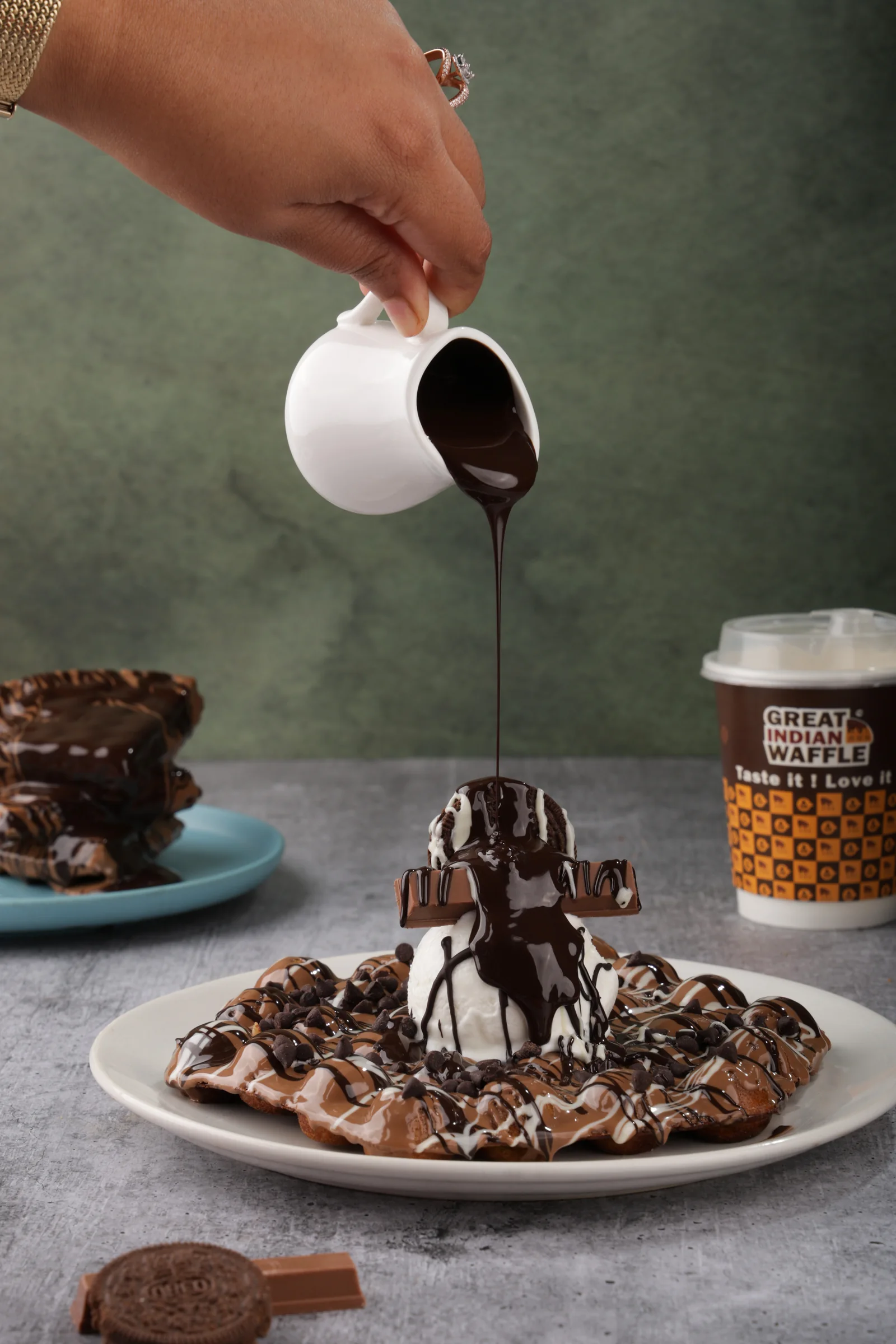 Chocolate being poured over a waffle